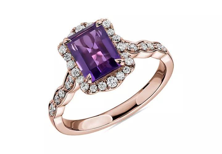 An emerald cut amethyst and diamond halo engagement ring in rose gold setting